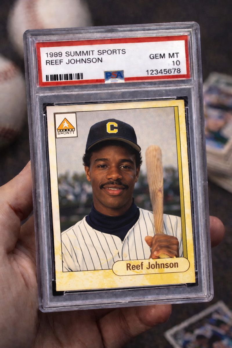 Graded baseball card in a clear slab, shown in gem mint condition and held in hand.